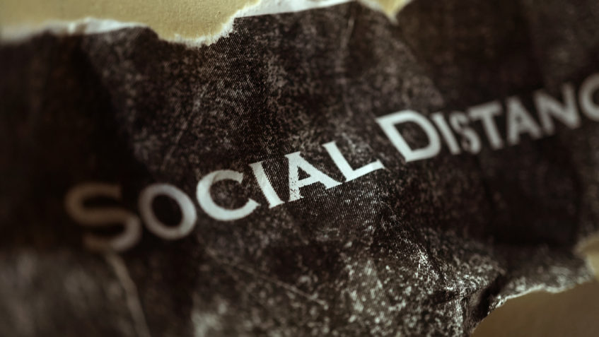 A crumpled piece of paper that reads "Social Distancing"